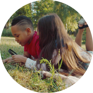 Boy and girl looking at grass through hand lens