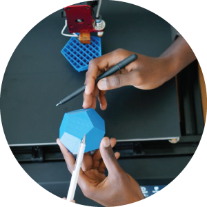 Hands pointing to a shape near a 3D Printing Apparatus