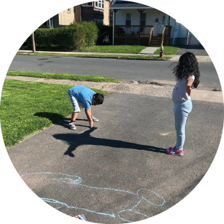 A boy traces someone’s shadow outside