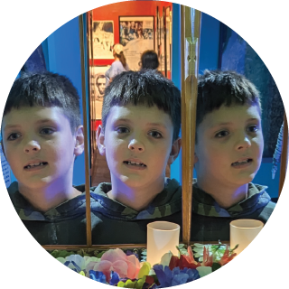 A boy’s reflection in several mirrors