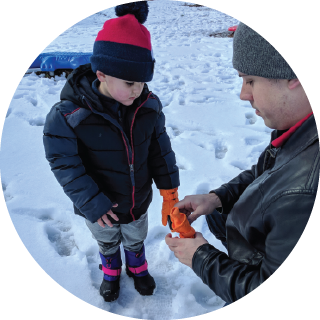 A boy and his dad look at snow