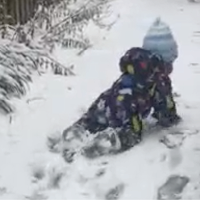 A baby crawling through the snow