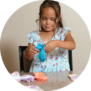 A girl sorts pairs of colored socks.