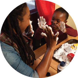 Mother and child playing with shaving cream