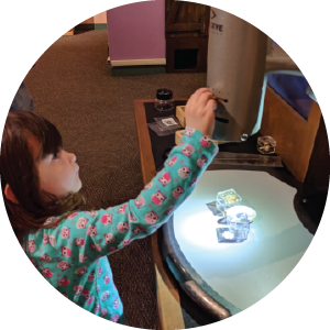 Girl with a giant spoon at a fountain